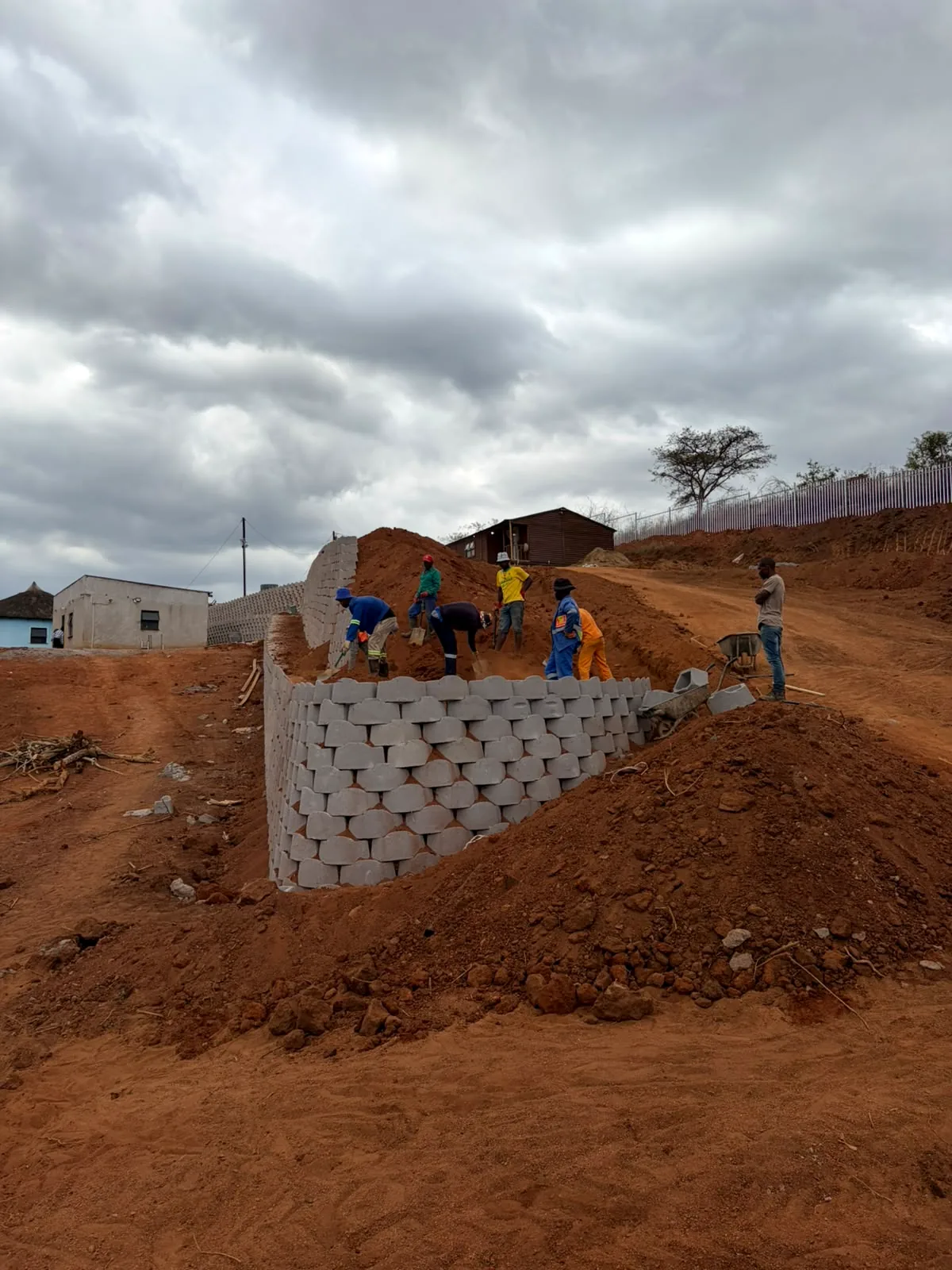 MADCON team constructing a retaining wall on a sloped site